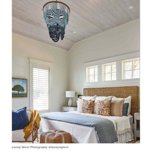 Coastal styled bedroom with a wood beaded chandelier